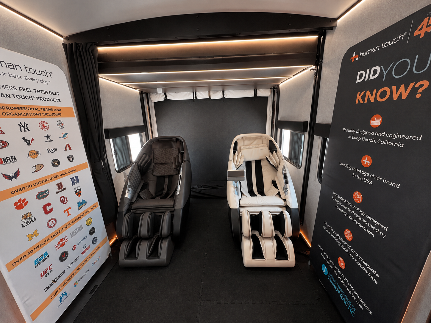 Interior of the lounge with two Human Touch massage chairs between branded banners