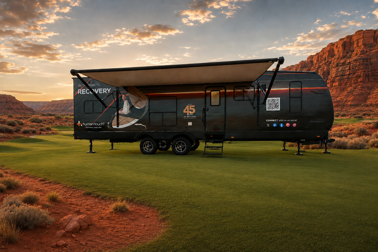 The Human Touch Recovery Lounge trailer parked on a manicured golf course green with red rock cliffs at sunset